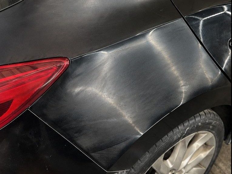 Black Mazda hatch with swirl marks on the rear quarter